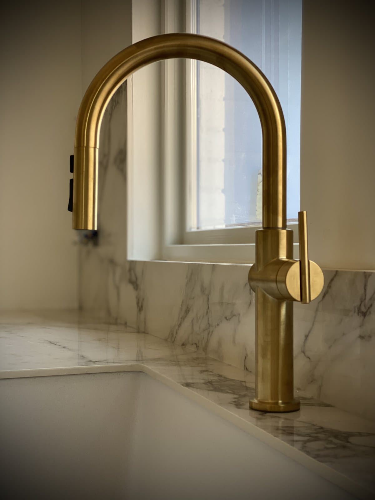 Brass faucet installed on a marble bathroom counter