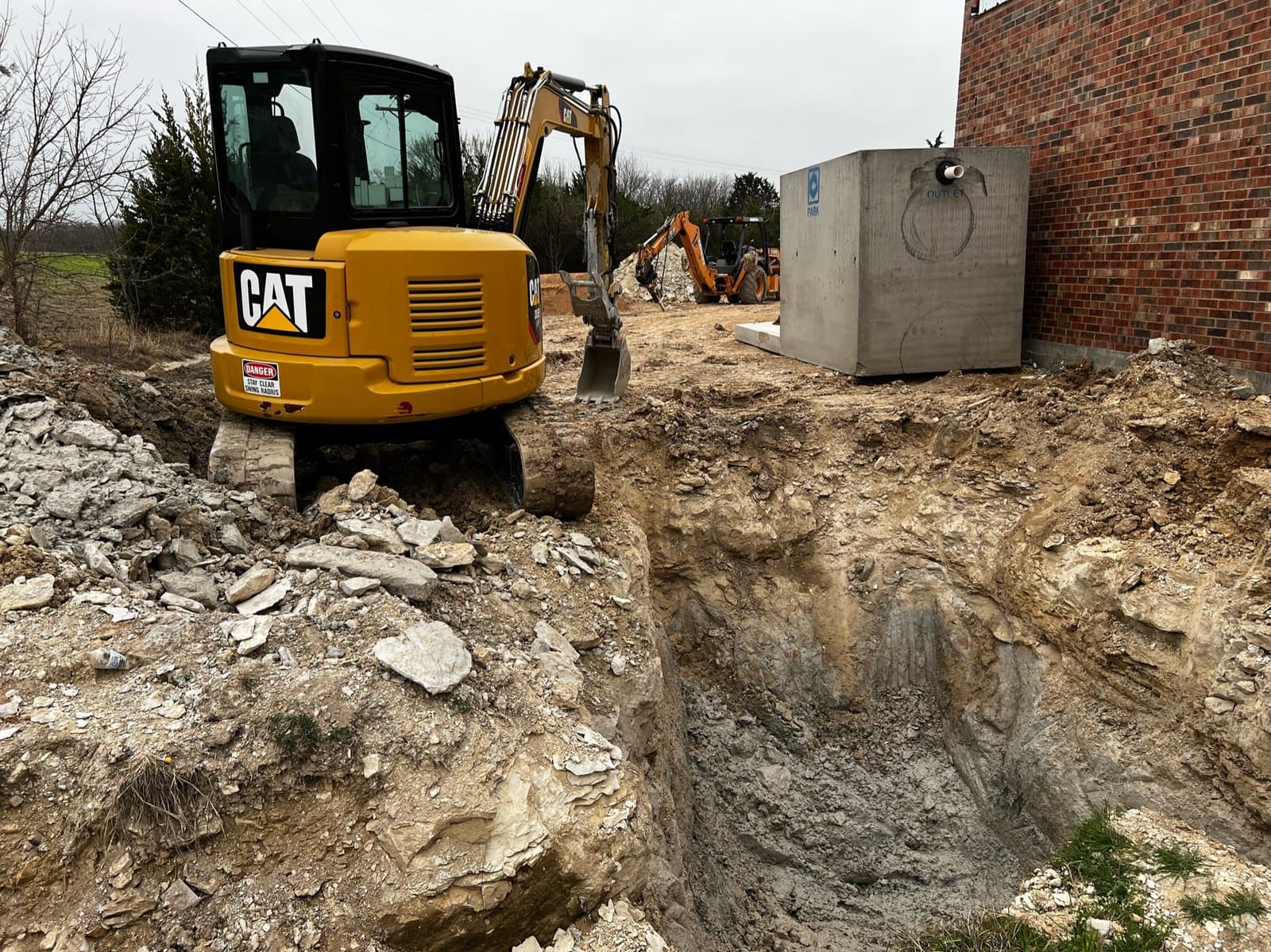 Deep sewer excavation beside a commercial building