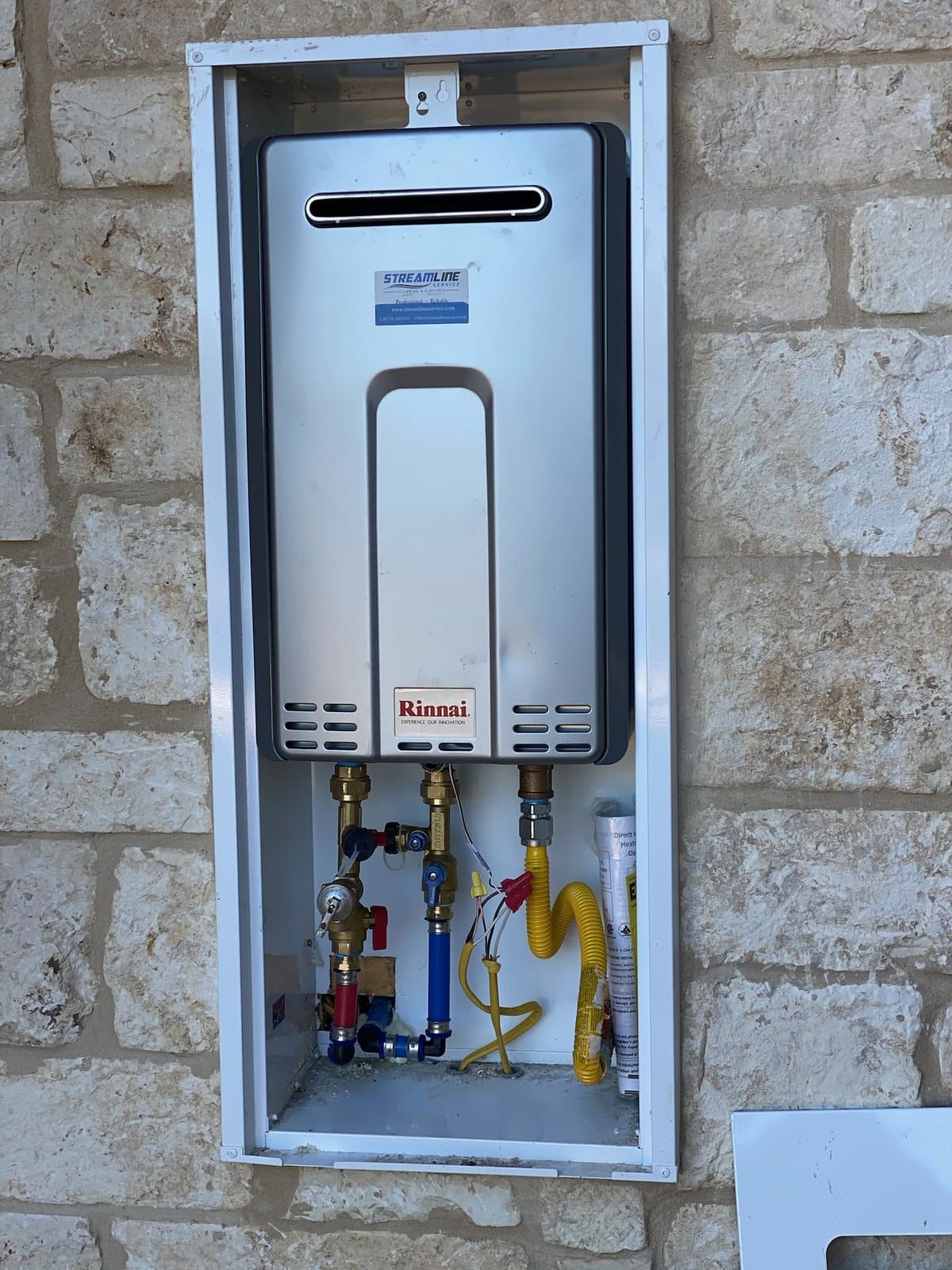 Open tankless water heater showing serviceable components