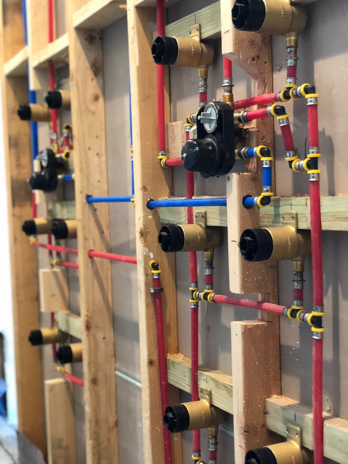 Open wall showing new plumbing rough-in during repipe work